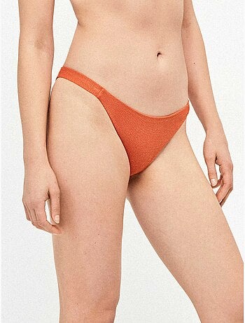 Bas de bikini classique en tissu texturé avec fils de lurex dorés et détails froncés sur les côtés.