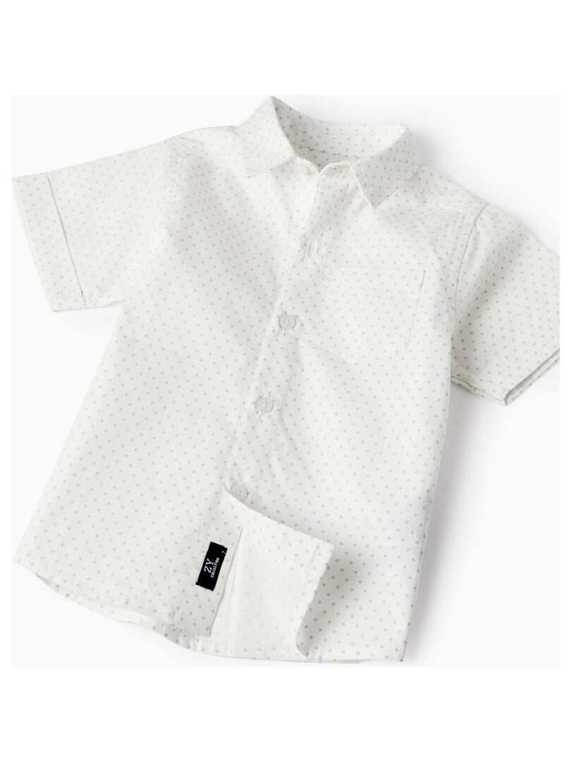 Tenue: Chemise à manches courtes blanche, Pantalon de costume noir, Chaussures derby en cuir marron, Nœud papillon noir | France