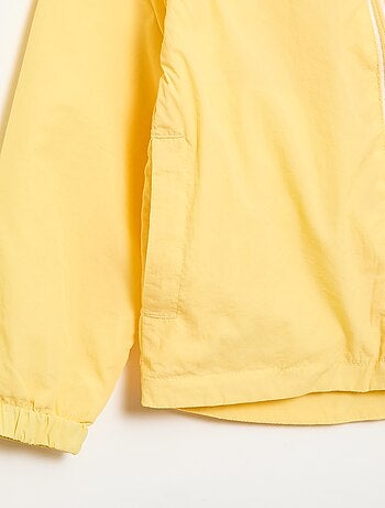 Coupe-vent uni qui se range dans sa capuche