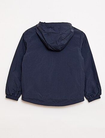 Coupe-vent uni qui se range dans sa capuche