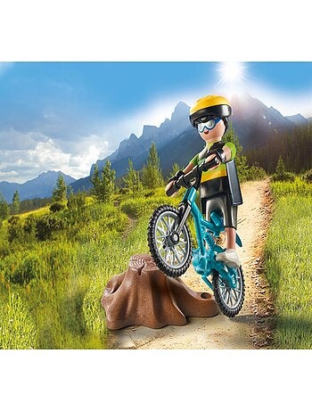 Cycliste avec vélo tout terrain et souche d'arbre