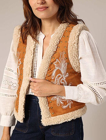 Gilet sans manches style daim, détails cloutés et broderie discrète. 'Deeluxe'