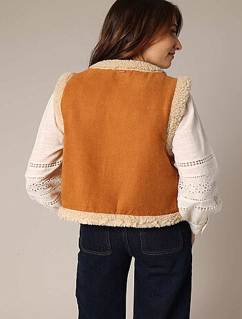 Gilet sans manches style daim, détails cloutés et broderie discrète. 'Deeluxe'