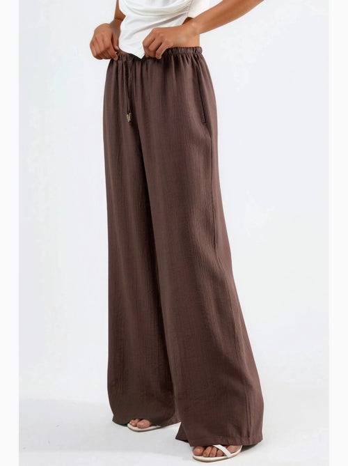 Pantalon à jambes larges et taille élastiquée avec cordon de serrage et poches busem - Kiabi Pantalon à jambes larges et taille élastiquée avec cordon de serrage et poches busem - Kiabi