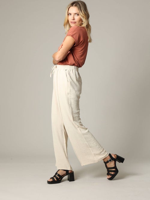 Pantalon fluide en tissu texturé avec taille élastiquée et double couture verticale 'Deeluxe' - Kiabi Pantalon fluide en tissu texturé avec taille élastiquée et double couture verticale 'Deeluxe' - Kiabi