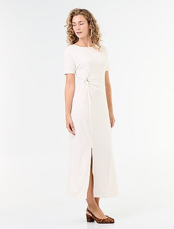 Robe longue coupe plissée et broche dorée martelée.