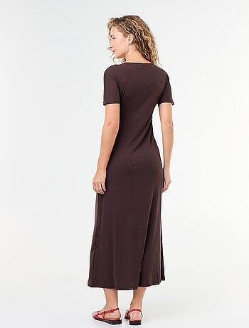 Robe longue coupe plissée et broche dorée martelée.