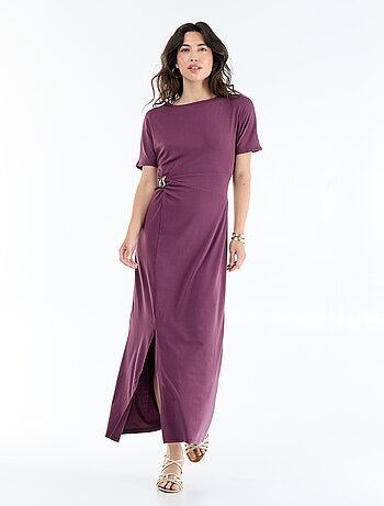 Robe longue coupe plissée et broche dorée martelée.