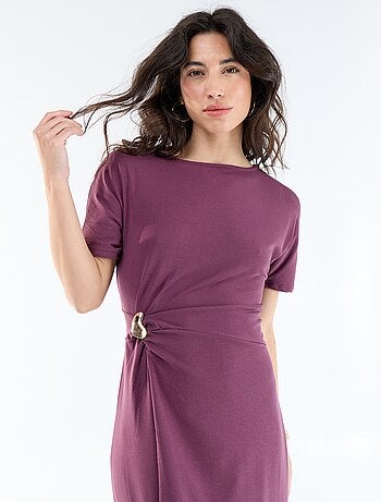 Robe longue coupe plissée et broche dorée martelée.