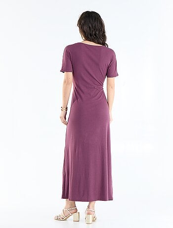 Robe longue coupe plissée et broche dorée martelée.