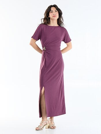 Robe longue coupe plissée et broche dorée martelée.