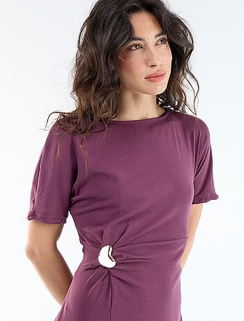 Robe longue coupe plissée et broche dorée martelée.