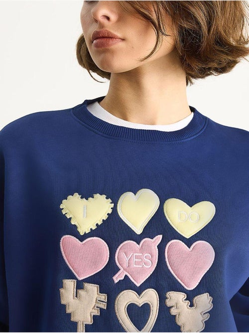 Sweat-shirt à col rond et coupe décontractée avec écusson cœur - Kiabi Sweat-shirt à col rond et coupe décontractée avec écusson cœur - Kiabi